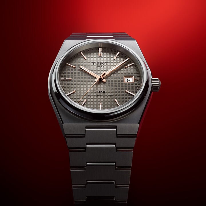 Tissot PRX Titanium in front of a red background 