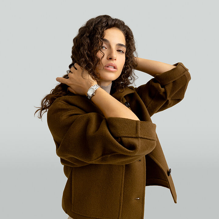 Femme se tenant les cheveux, une montre Tissot &agrave; la main