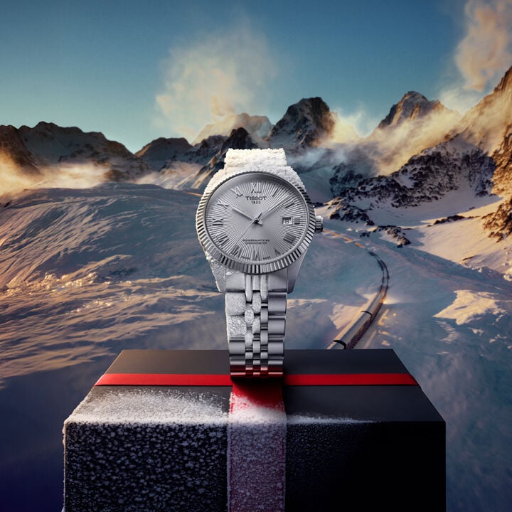 Man wearing a Tissot watch holding a wrapped gift box