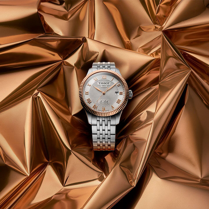 Tissot Le Locle gold model floating on a dark gold background