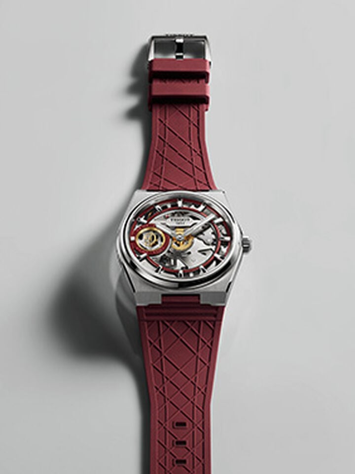 Tissot PRX Skeleton Damian Lillard Edition with a stainless steel case, burgundy rubber strap, skeleton dial, and Damian Lillard monogram against a light gray background.