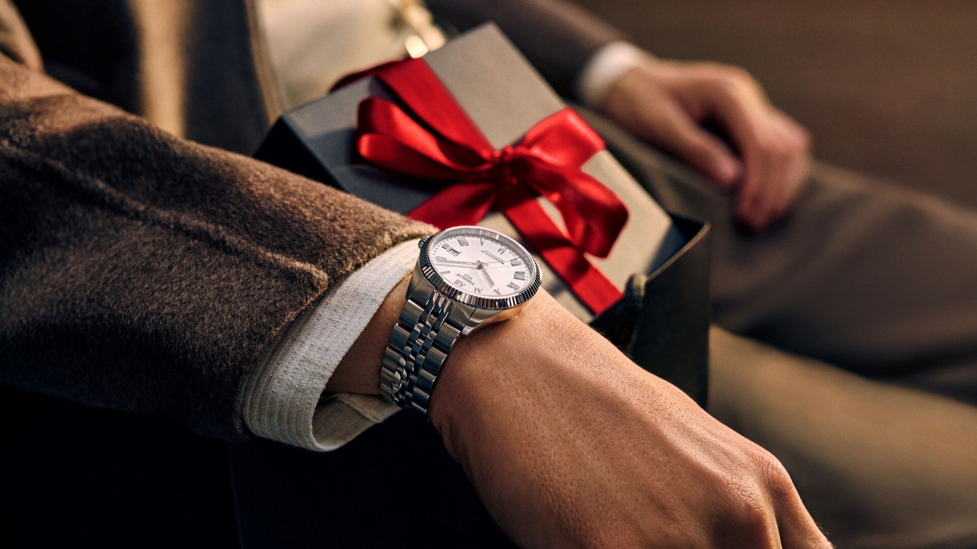 Wrist with Tissot watch and gift box