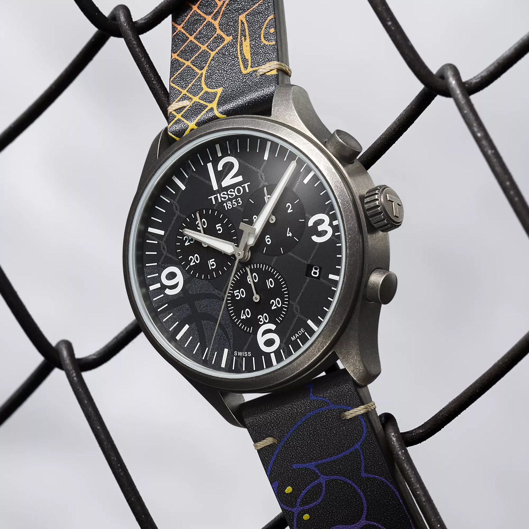 Tissot Chrono XL 3x3 Street Basketball watch on a colored background