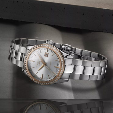 Tissot T-My Lady Gold 29mm watch on a coloured background