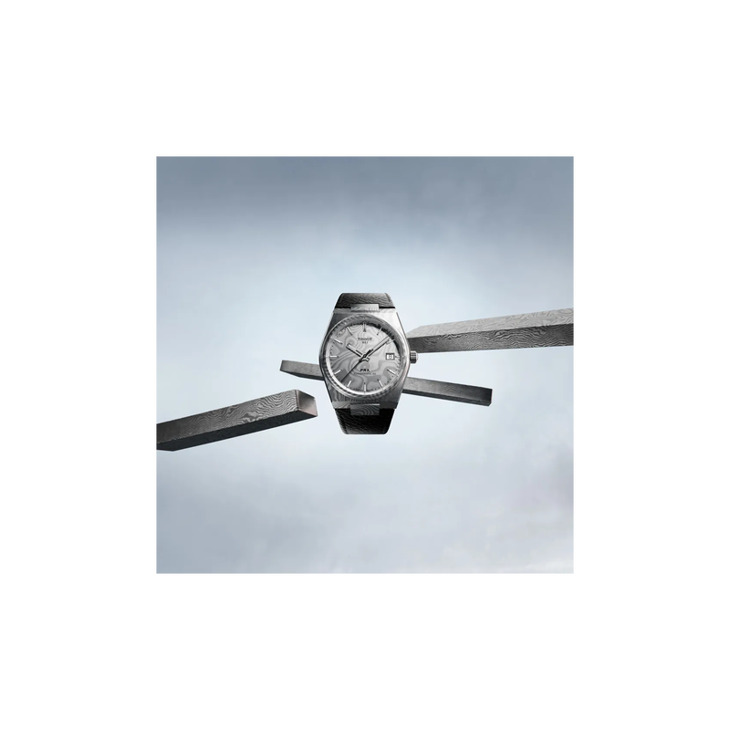 Tissot PRX Damascus Steel 38mm watch on a colored background