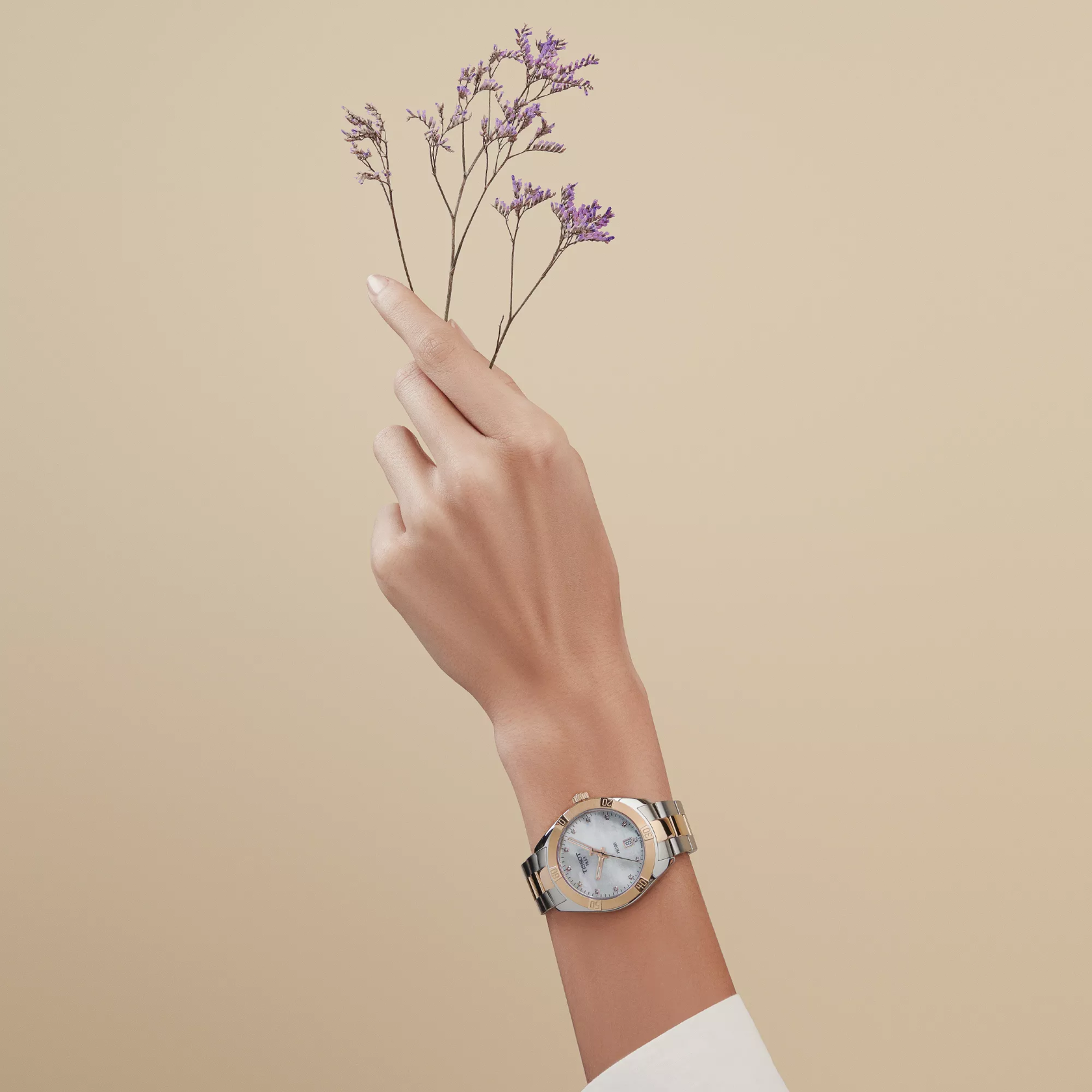 Tissot PR 100 Sport Chic 36mm watch on a colored background