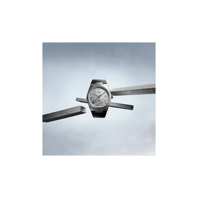 Tissot PRX Damascus Steel 38mm watch on a coloured background