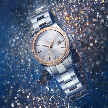 Tissot T-My Lady Gold 29mm watch on a coloured background