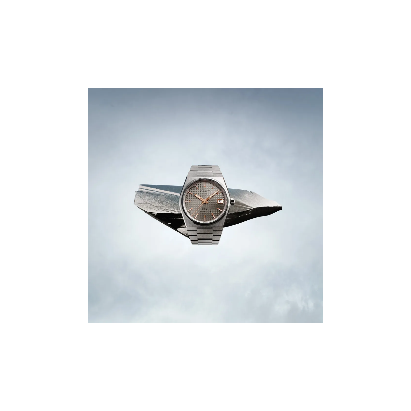 Tissot PRX Titanium 38mm watch on a colored background