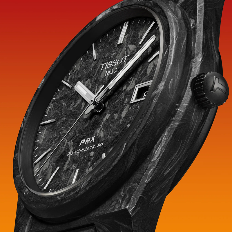 Tissot PRX Carbon 40.5mm watch on a colored background