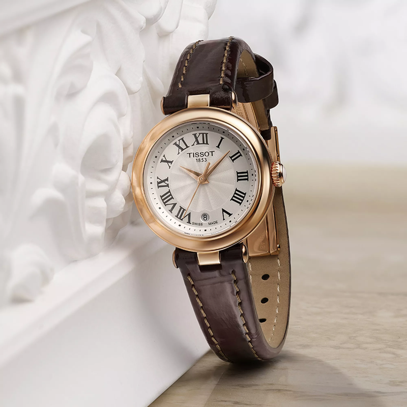 Tissot Bellissima 26mm watch on a coloured background