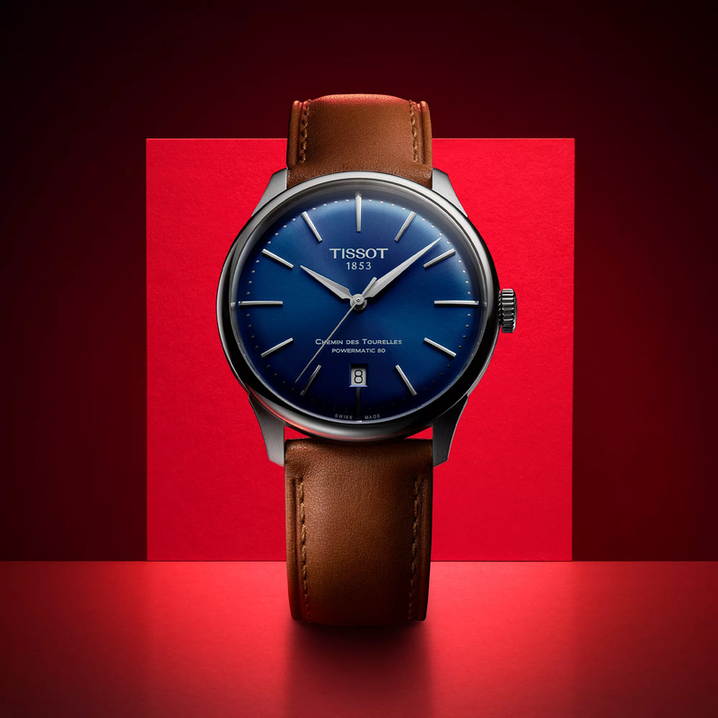 Tissot Chemin des Tourelles 42mm watch on a colored background