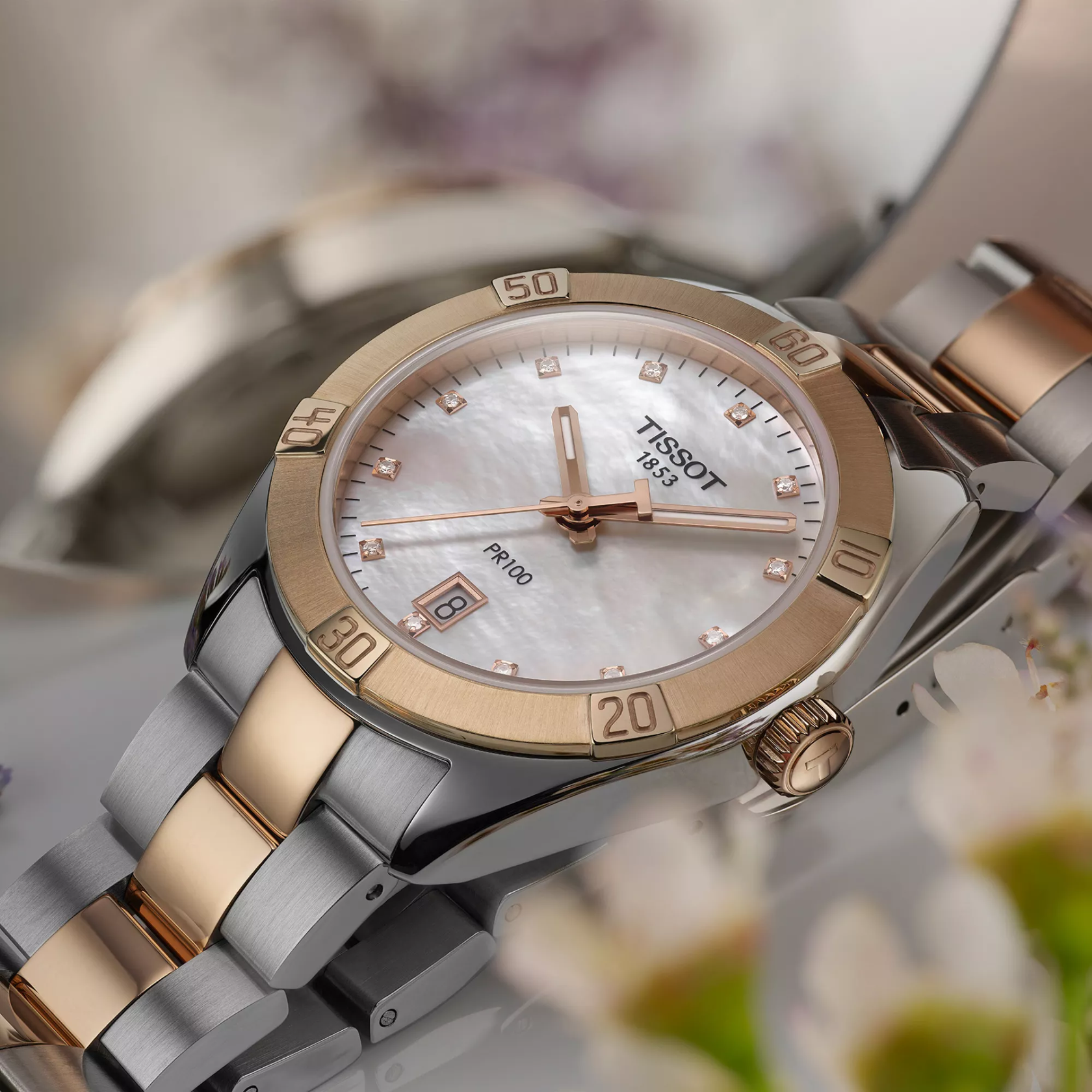 Tissot PR 100 Sport Chic 36mm watch on a colored background