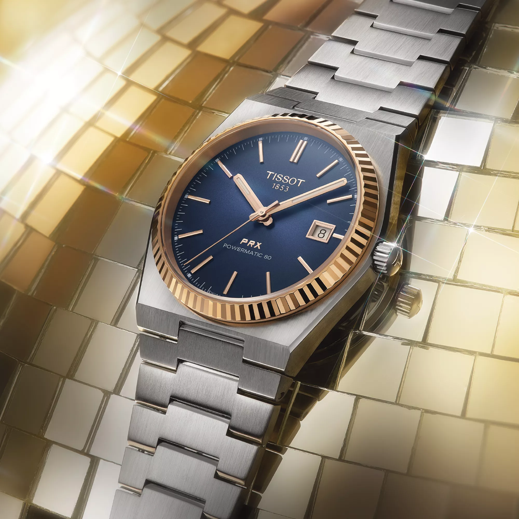 Tissot PRX Gold 40mm watch on a colored background