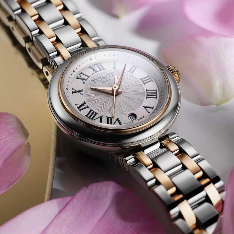 Tissot Bellissima 26mm watch on a colored background