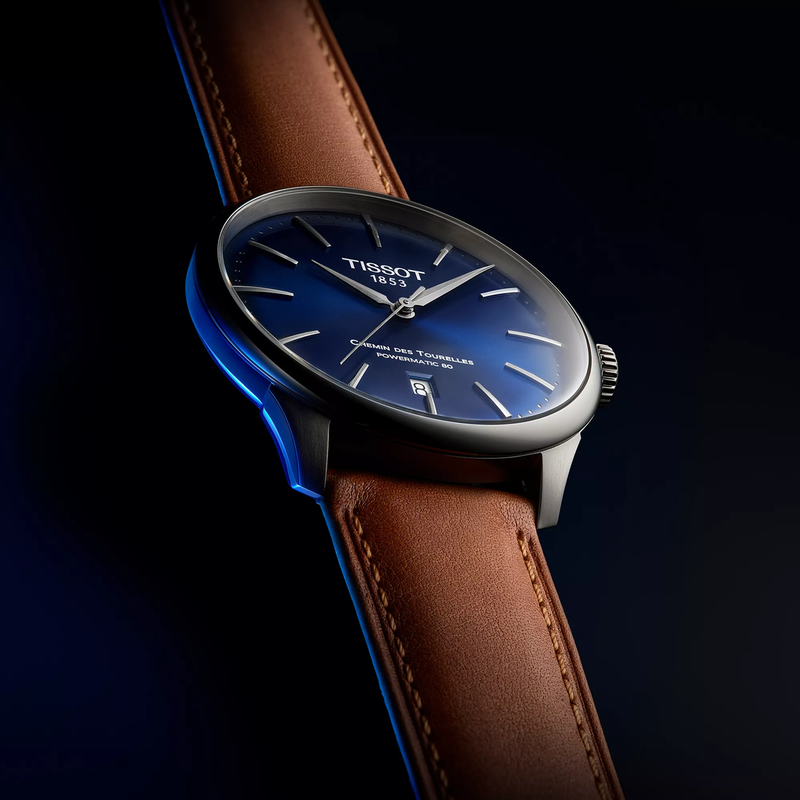 Tissot Chemin des Tourelles 42mm watch on a colored background