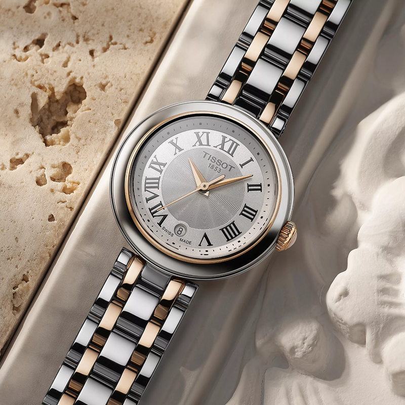 Tissot Bellissima 26mm watch on a colored background