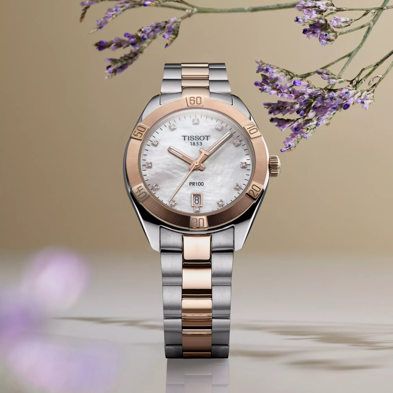 Tissot PR 100 Sport Chic 36mm watch on a colored background