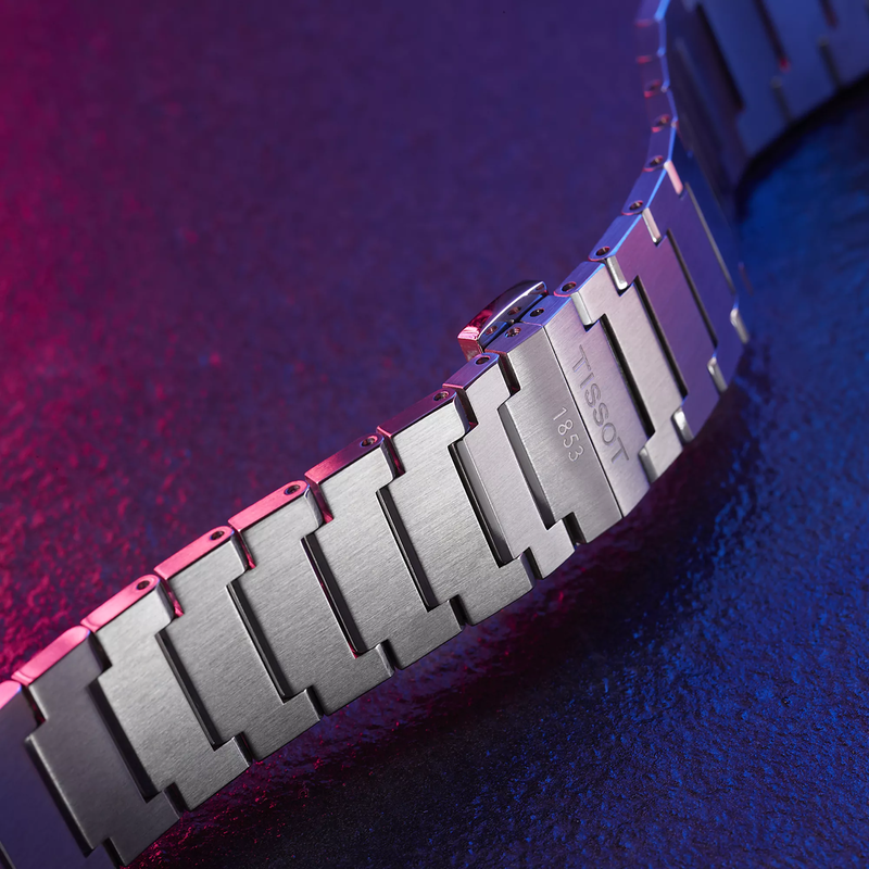 Tissot PRX 40mm horloge op een gekleurde achtergrond