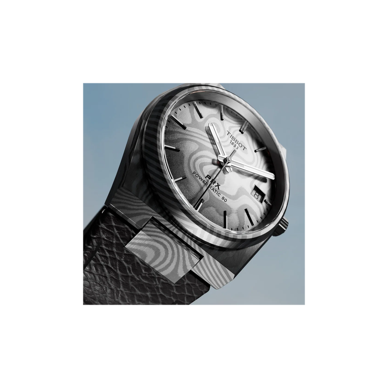 Tissot PRX Damascus Steel 38mm watch on a coloured background