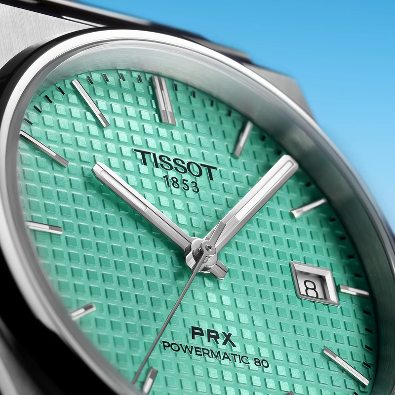 Tissot PRX 40mm Uhr vor einem farbigen Hintergrund