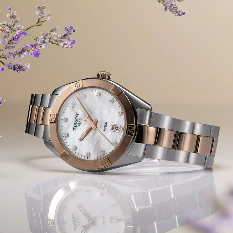 Tissot PR 100 Sport Chic 36mm watch on a colored background