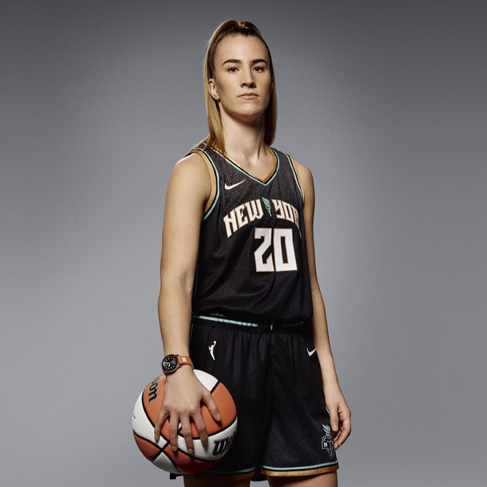 Portrait of the new Tissot ambassador Sabrina Ionescu, in her basketball jersey and holding a basketball.