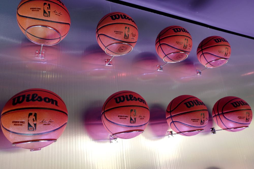 Photo of a wall with eight Wilson NBA basketballs hanging from it