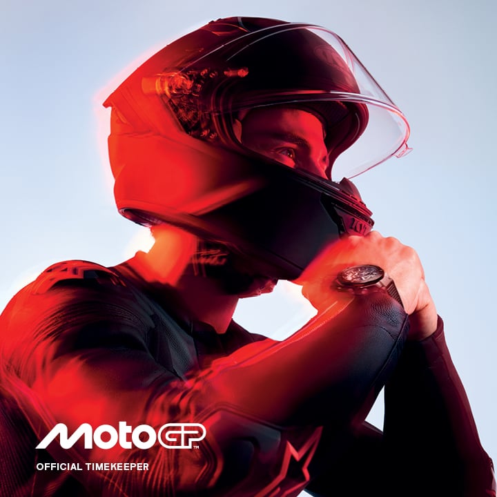 Ein Motorradfahrer in Lederkombi setzt seinen Helm auf, am Arm tr&auml;gt er eine Tissot Uhr.