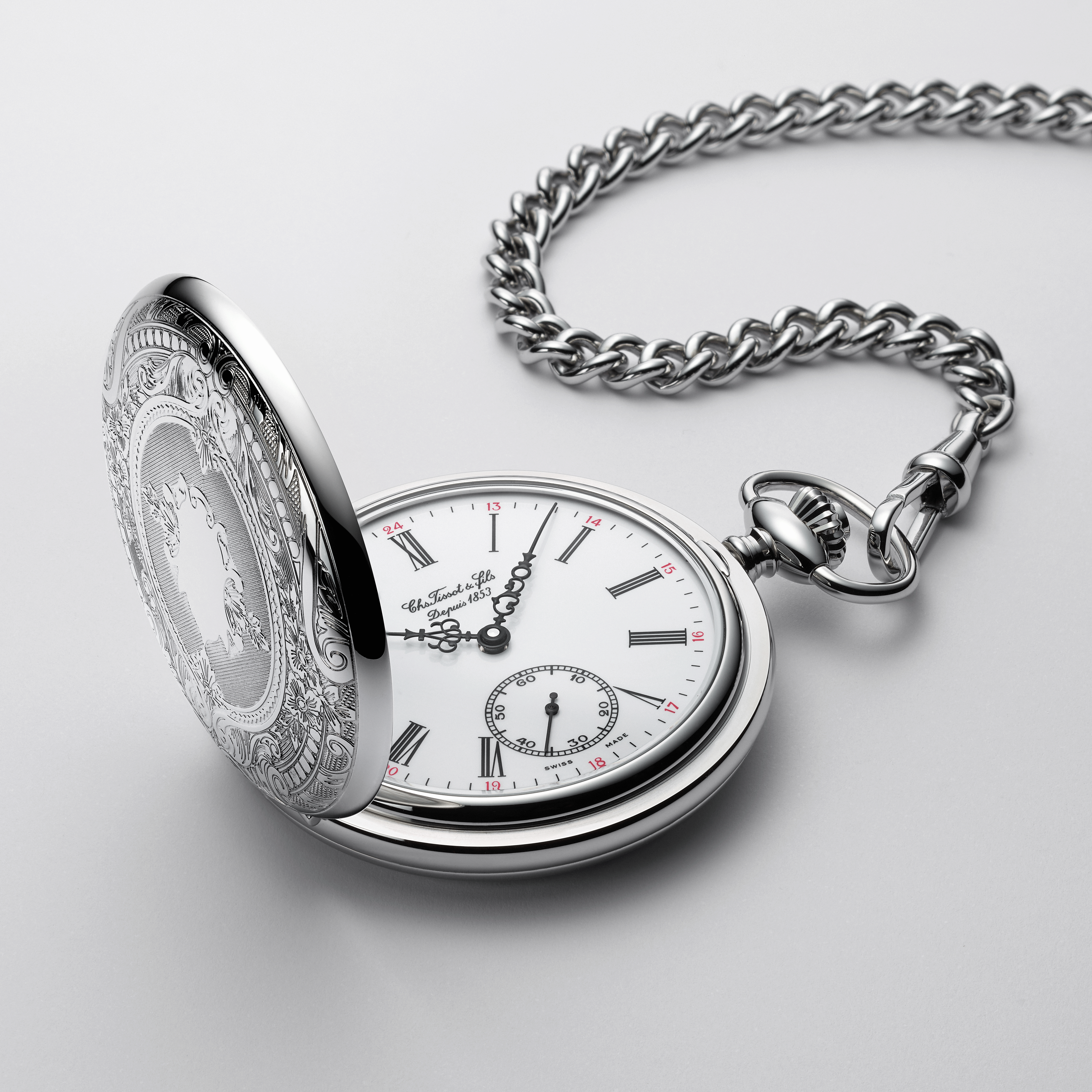 Close up of a pocket watch with a white dial and roman numeral indexes