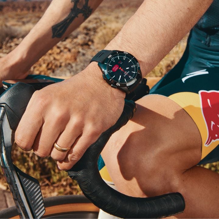 Close-up of Primož Roglič&rsquo;s wrist on his bike, wearing the Tissot T-Touch Connect Sport watch.