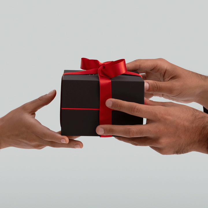 Person handing a wrapped gift box to someone else
