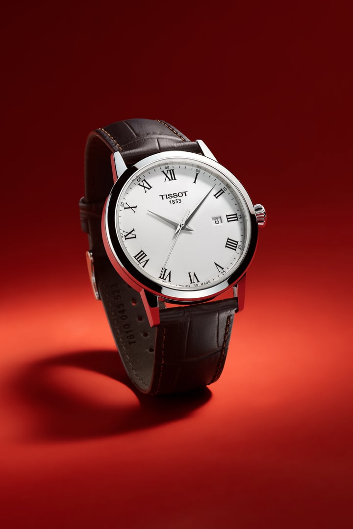 Tissot watch with white dial on a red background