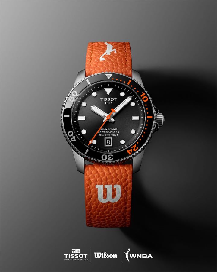 Tissot Seastar Wilson WNBA model with black dial and orange strap on black background, with Tissot, Wilson and WNBA logos