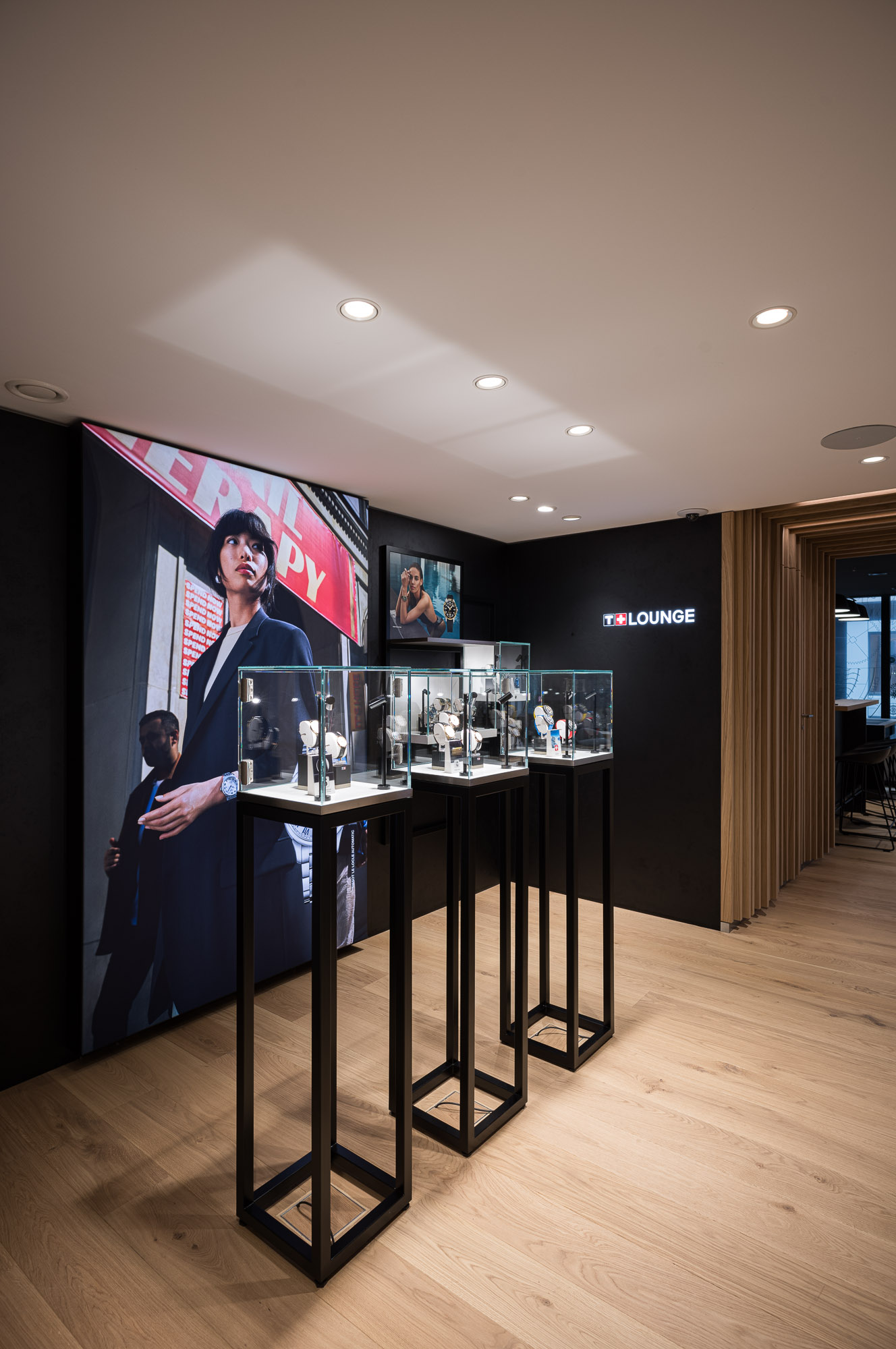 Innenansicht des Tissot-Gesch&auml;fts in Frankfurt, mit eleganten Vitrinen voller Uhren und dynamischen Grafiken an den W&auml;nden.