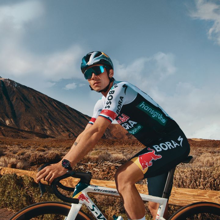 Primož Roglič, Tissot ambassador, cycling while wearing the Tissot T-Touch Connect Sport watch on his wrist.
