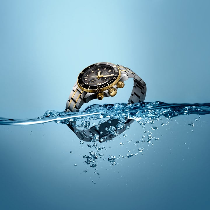 Angled black and gold watch in water