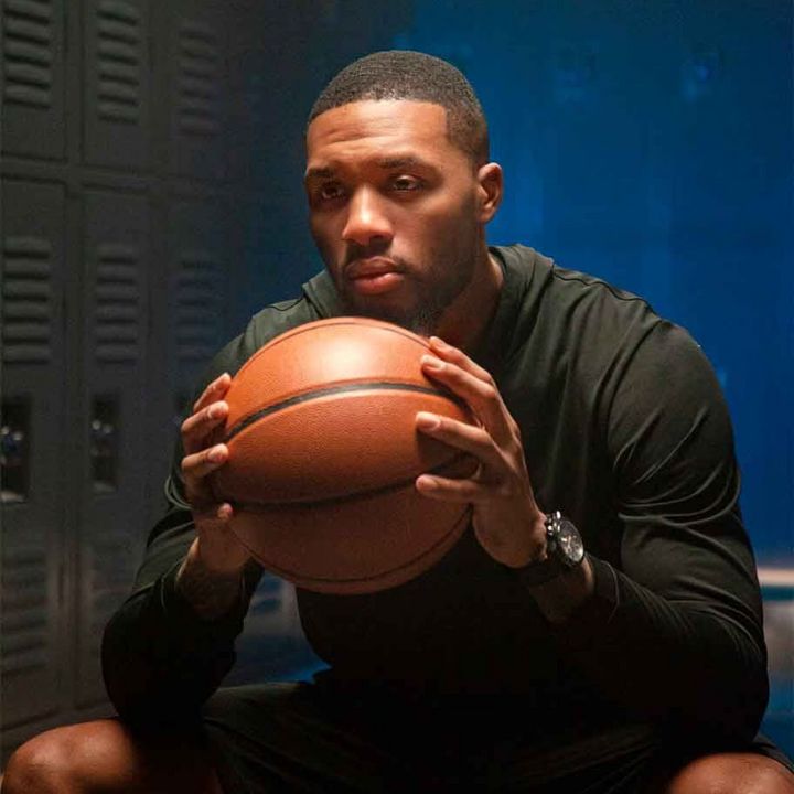 Tissot ambassador Damian Lillard posing with a basketball in his hands and a Tissot watch on his wrist