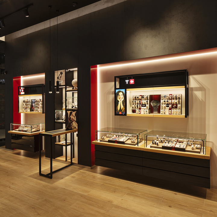 Interno della boutique Tissot a Milano, con design moderno, dettagli rossi iconici e vetrine raffinate che esaltano l&rsquo;arte orologiera