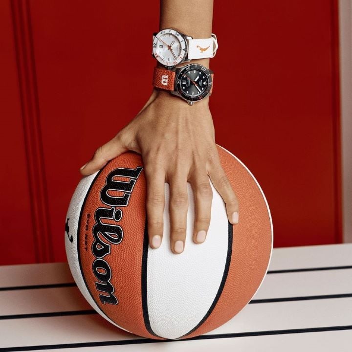 Focus on the official Wilson WNBA basketball being held by a hand with the two new Tissot Seastar Wilson WNBA watches on the wrist