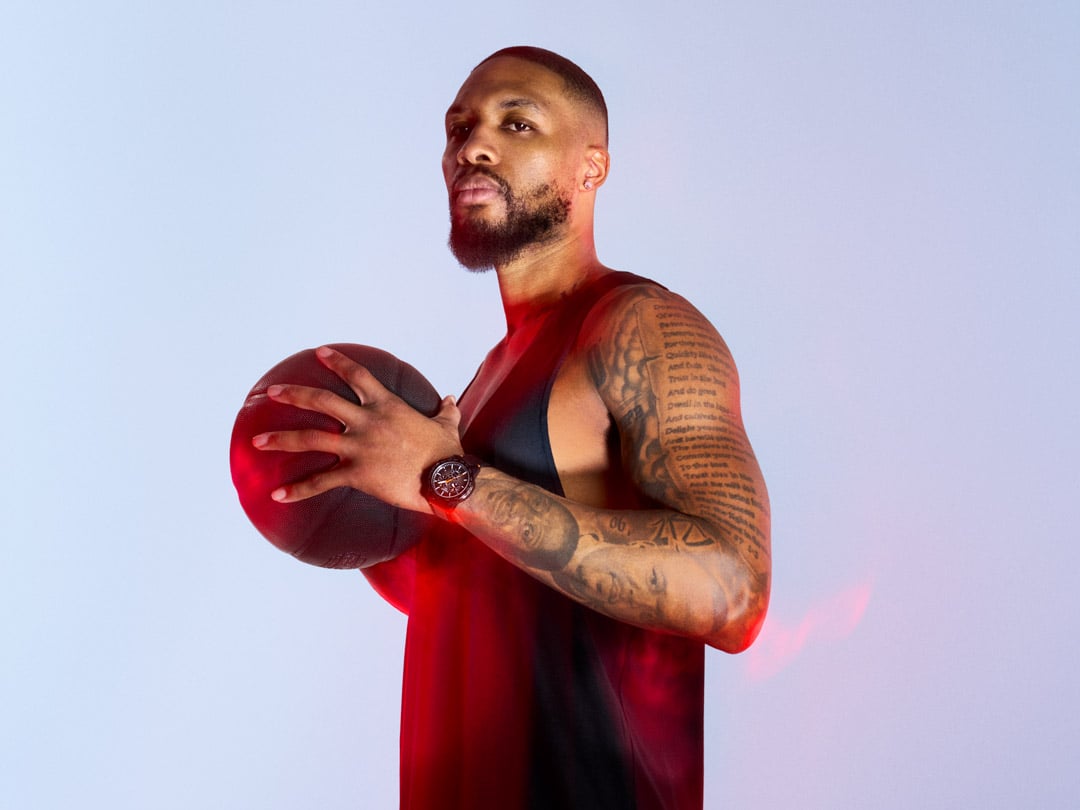 Damian Lillard posant de profil tenant un ballon entre ses mains et portant une montre Tissot