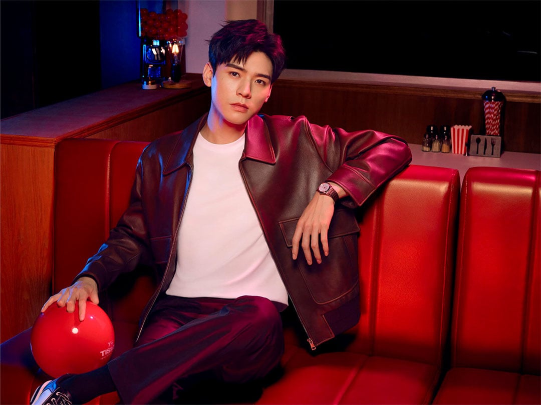 Simon Gong Jun seated on red couch and holding a red bowling ball