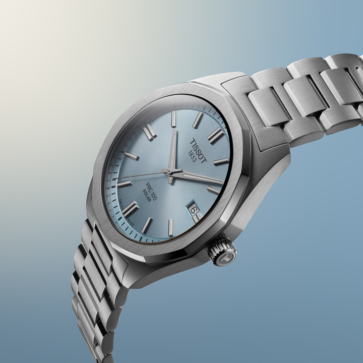 Tissot PRC 100 Solar watch with a light blue dial and stainless steel bracelet.