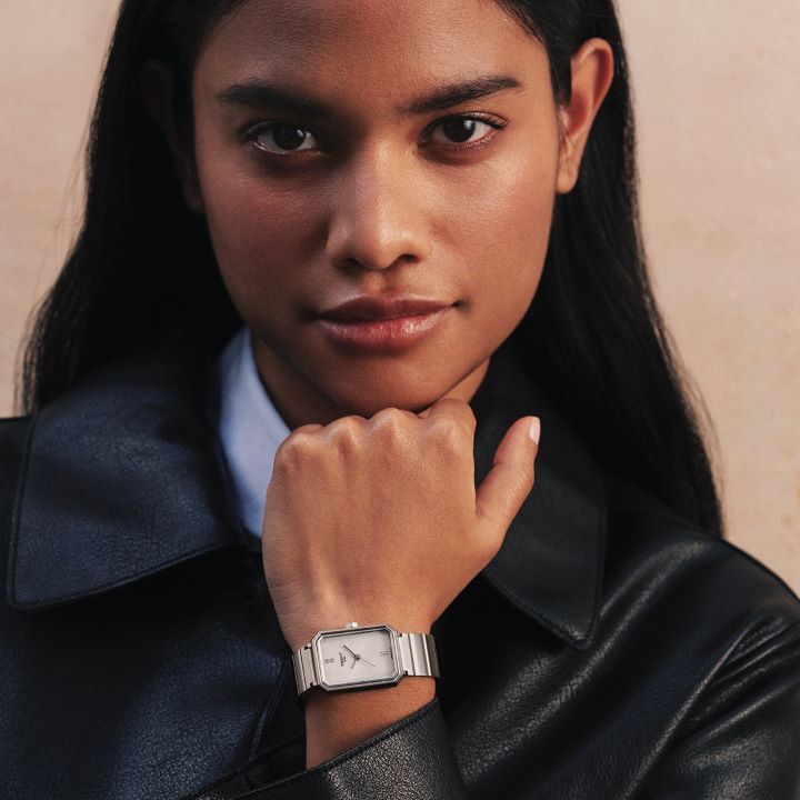 Tissot SRV stainless steel watch with grey dial, showcased on a model&rsquo;s wrist, styled with a black leather jacket.