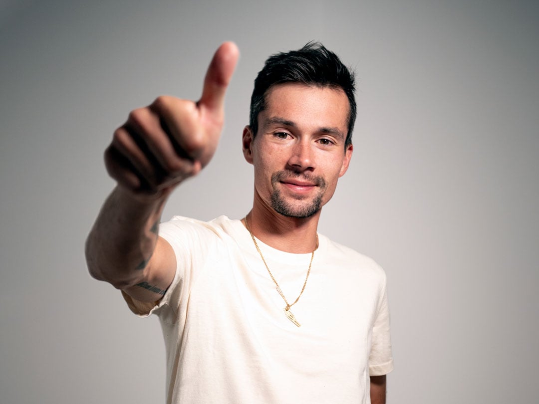Primož Roglič smiling, thumbs up in the air