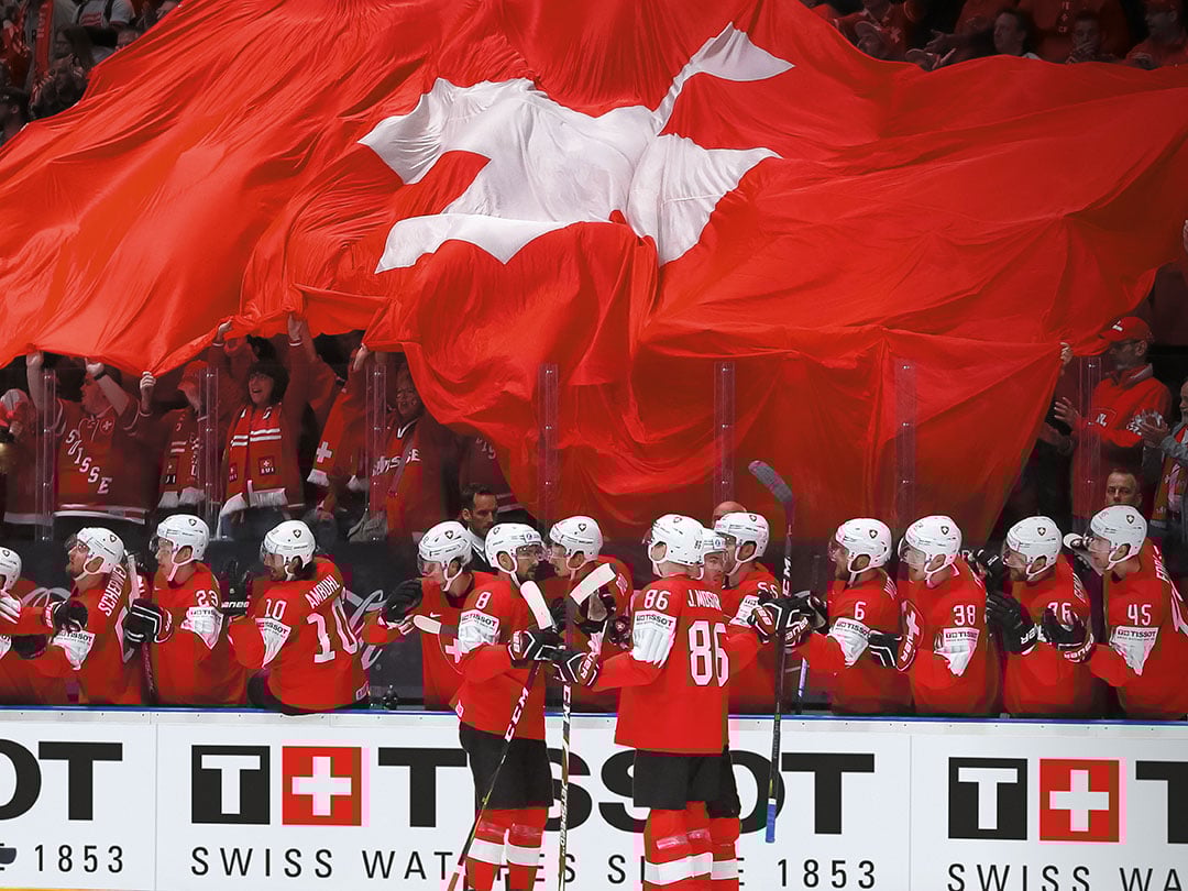 Ice Hockey players supporting their favourite team under a huge Swiss flag 