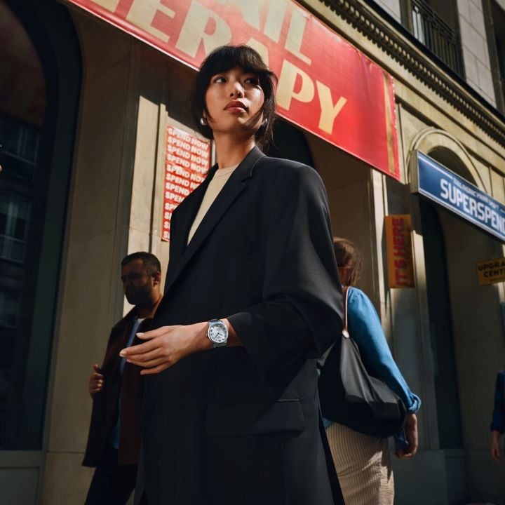 Female model walking in a street with the Tissot Le Locle Powermatic 80 20th Anniversary on her wrist