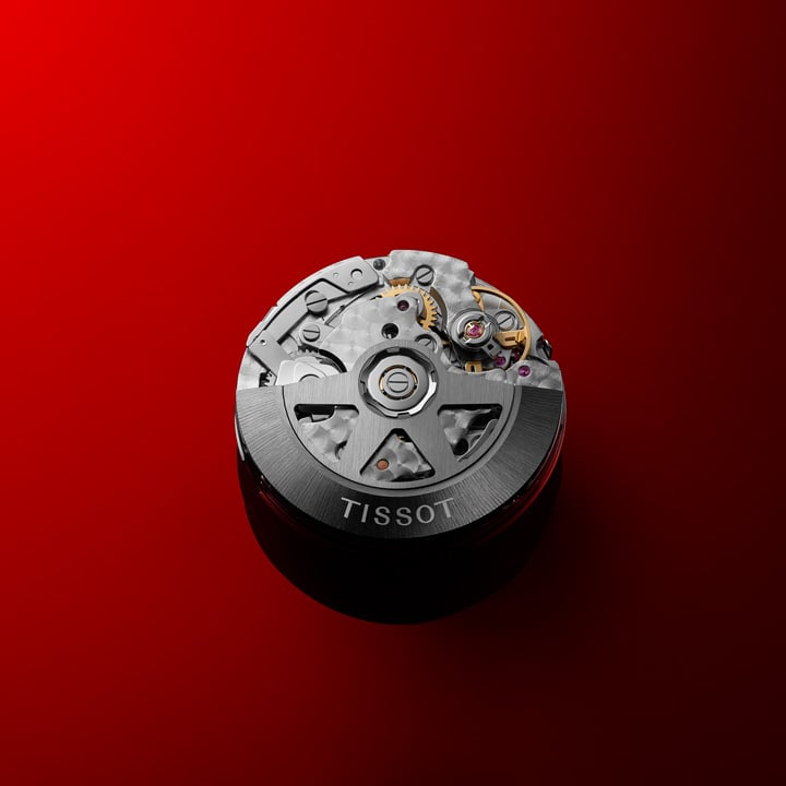 Tissot PR516 movement against a red background