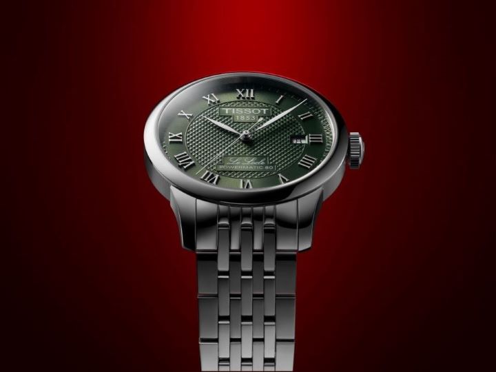 Montre Tissot Le Locle avec cadran vert et bo&icirc;tier enti&egrave;rement en acier, sur fond rouge fonc&eacute; et noir.
