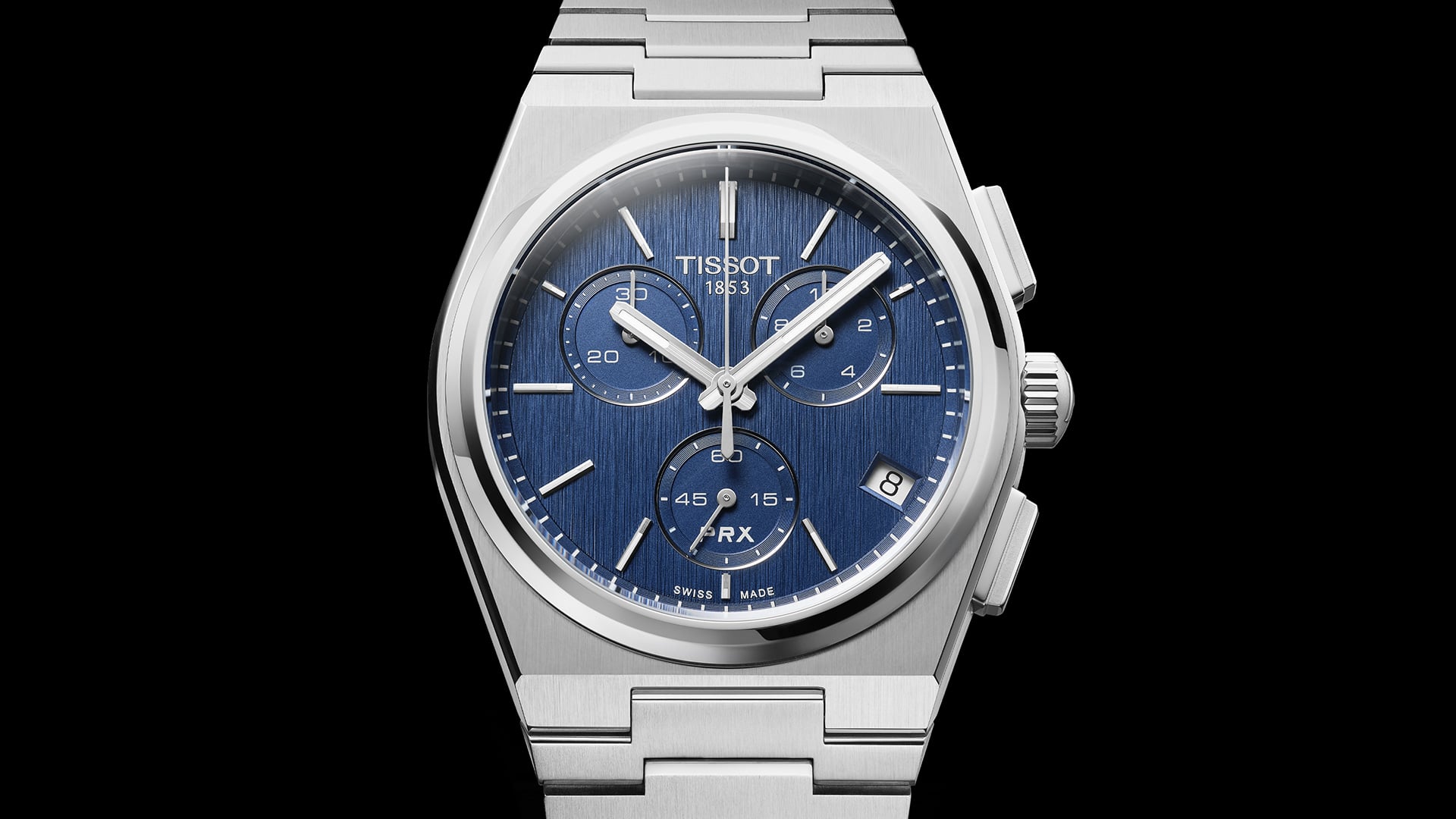 La montre Tissot PRX Quartz Chronograph en acier avec un cadran bleu fonc&eacute; vue de face sur un arri&egrave;re-plan noir 